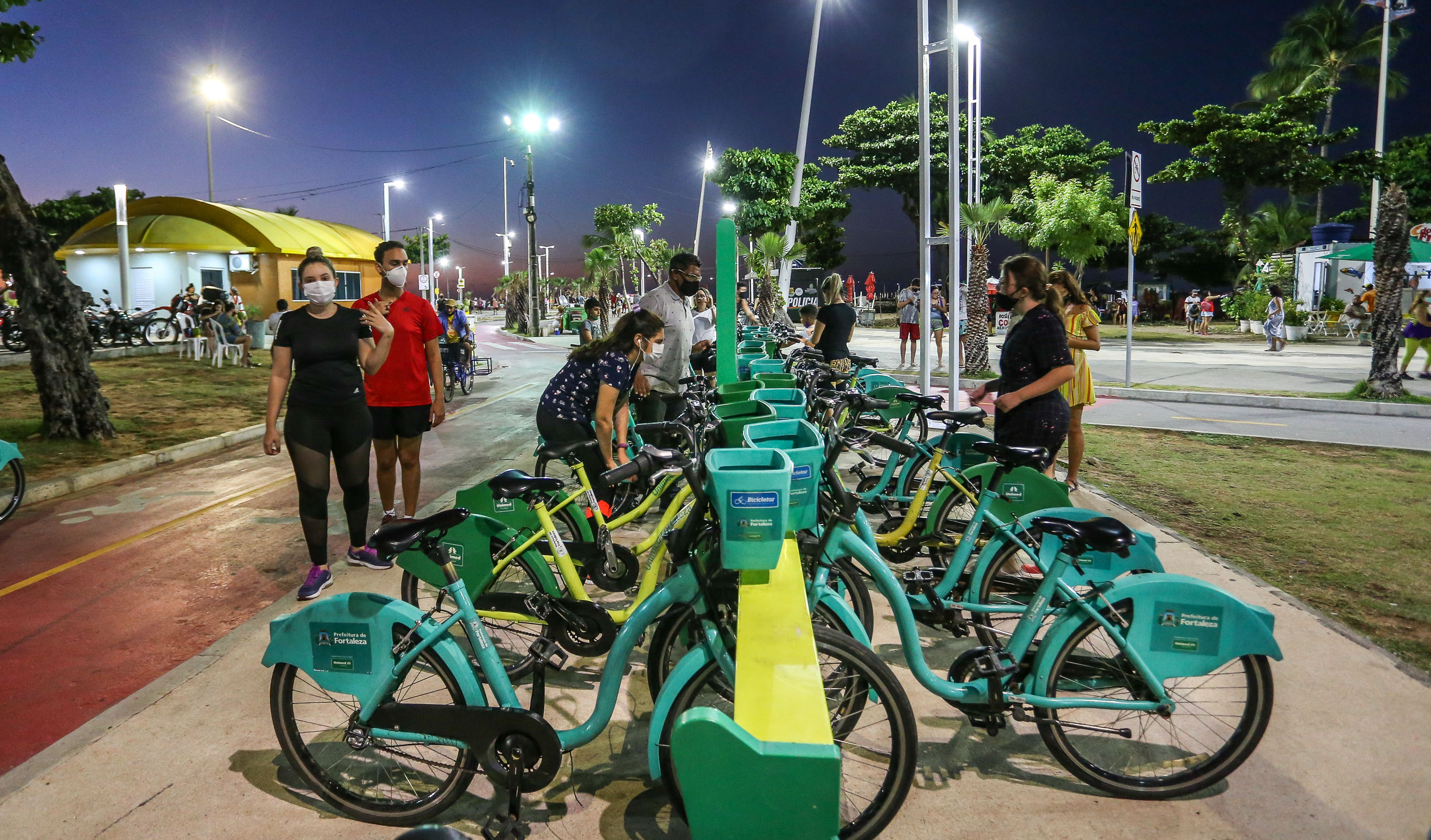 pessoas retirando bicicletas na estação do bicicletar em frente ao náutico